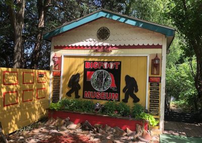 Bigfoot Museum Nebraska Directory Yellow and red Bigfoot Museum building nestled among trees in Hastings