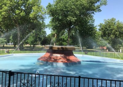 Hastings Park Fountain Nebraska Directory Ornamental fountain spraying water in a park surrounded by mature trees